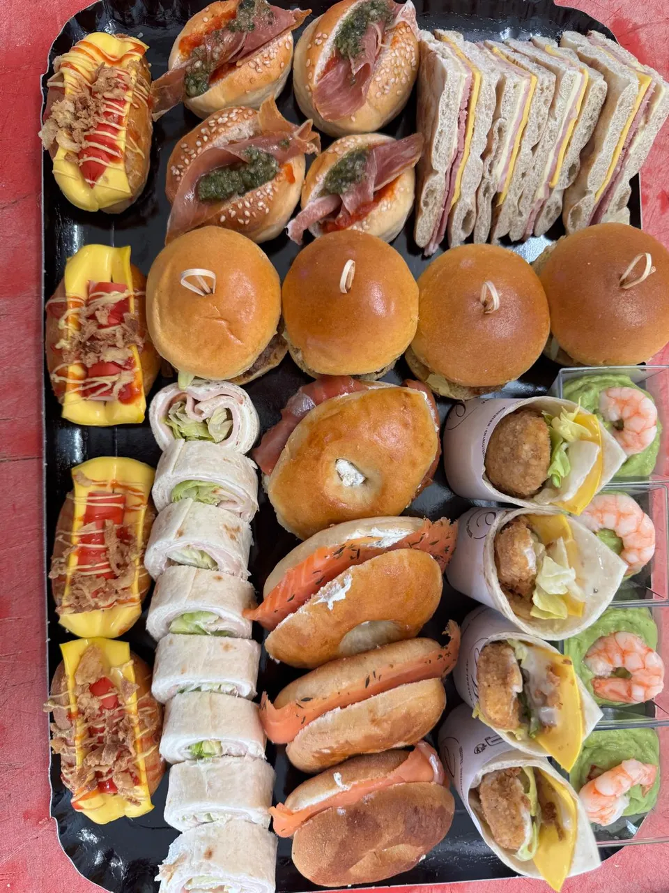 Plateau de sandwichs cocktail : bagels au jambon cru et au saumon, club sandwichs, mini burgers, wraps et verrines de crevettes