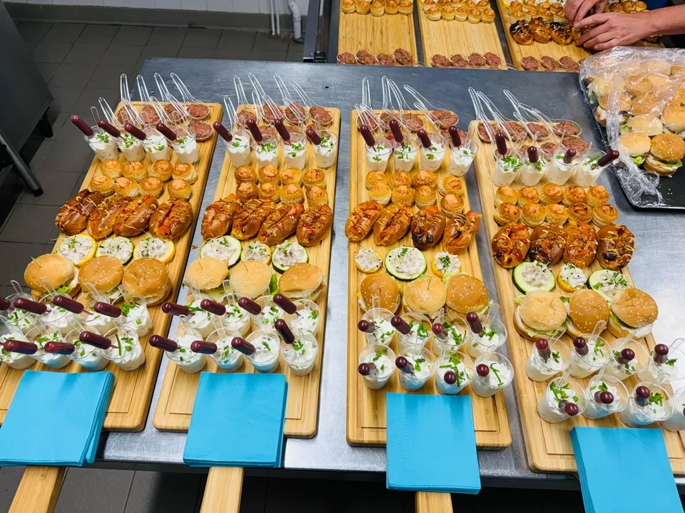 Planches apéritives en cuisine : verrines, mini burgers, brioches garnies et bouchées feuilletées, avec serviettes turquoise