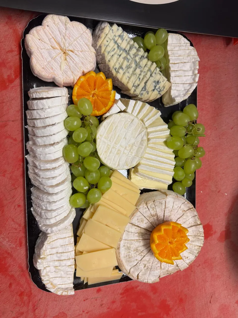Plateau de fromages : pâtes molles à croûte fleurie, bleu, pâte pressée en lamelles, raisin blanc et oranges ciselées