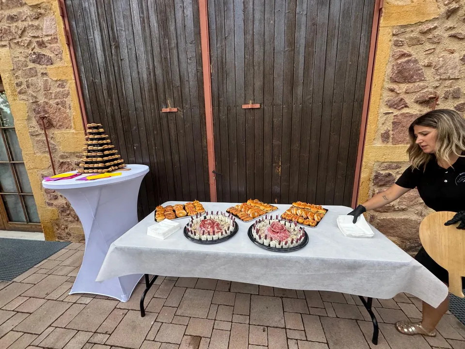 Buffet cocktail en extérieur : plateaux de mini burgers et de verrines, mange-debout et pyramide de macarons, mise en place en cours