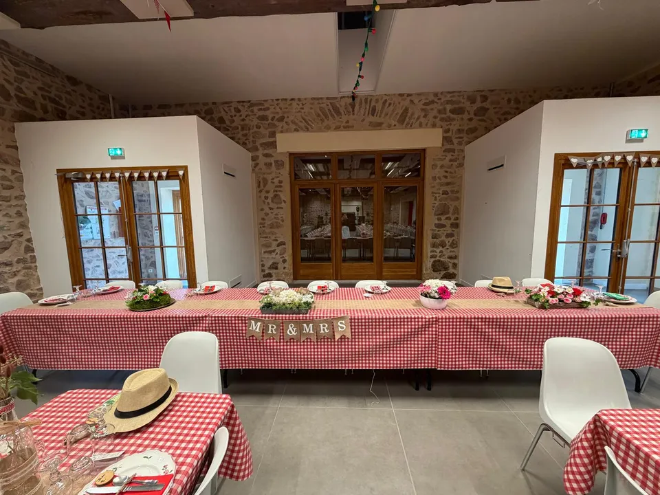 Table d’honneur des mariés avec nappe vichy rouge, chemin de table en toile de jute, bouquets et fanion Mr & Mrs