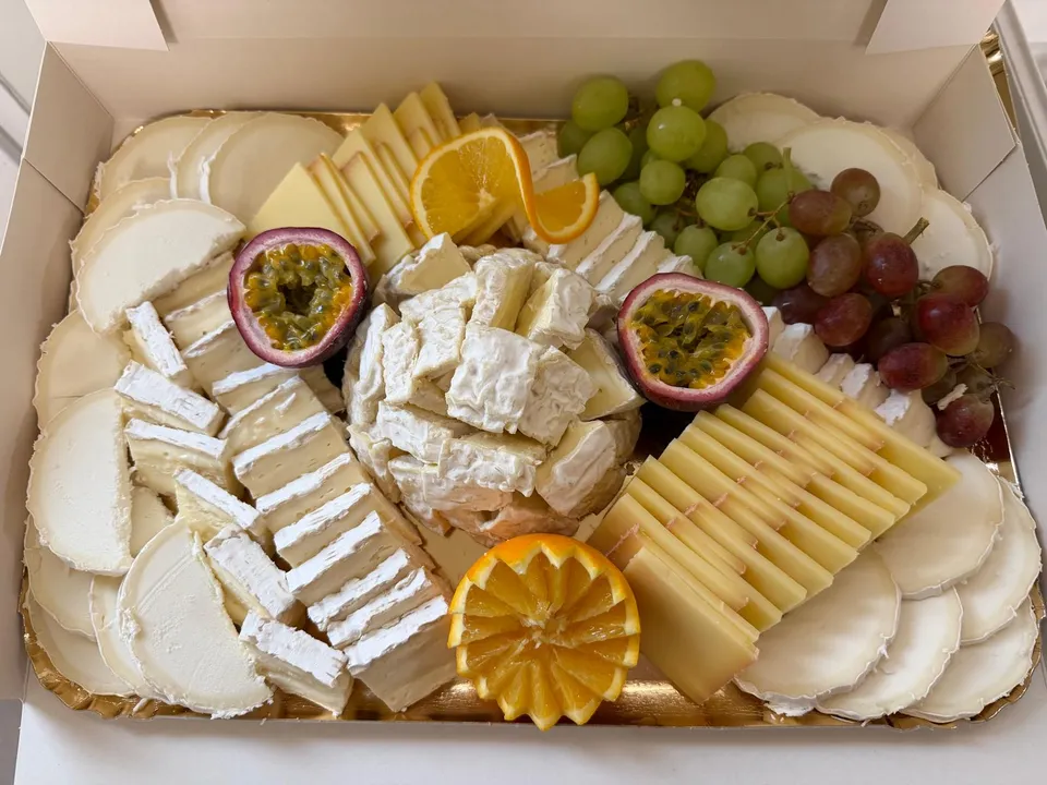 Coffret de fromages : rondelles de fromage frais, pâtes molles, pâte pressée, raisin, fruits de la passion et orange ciselée